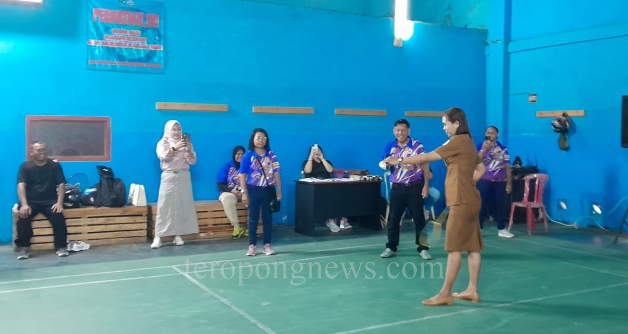 Sekretaris Bapopsi Papua Selatan, Lodevika Maturbong membuka pertandingan bulu tangkis dengan pukulan service