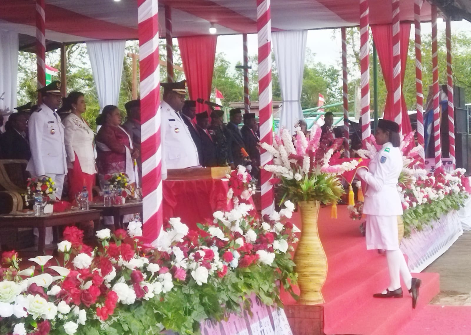 Siswi SMKN 1 Agats, Nada Dendew membawa baki berisi bendera Merah Putih yang diserahkan oleh Bupati Elisa Kambu untuk dikibarkan oleh Paskibra, Sabtu (17/8/2024)